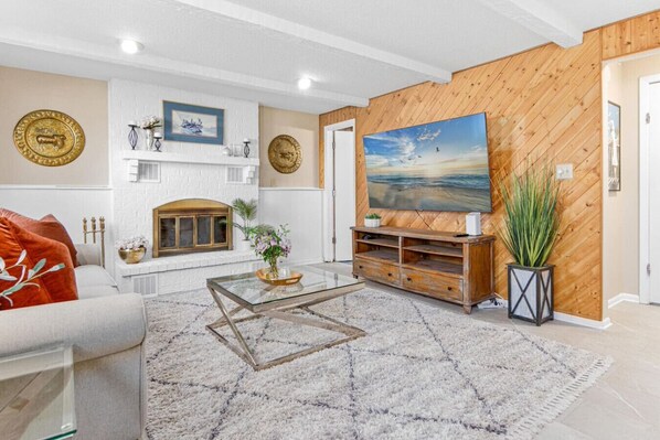 A living room with a fireplace, a large painting, and a wooden accent wall.