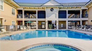 A hotel with a central pool, multiple balconies, and outdoor seating areas. - Coligny Beach, Pools, & Shops- Few Steps Away (Hilton Head Island)