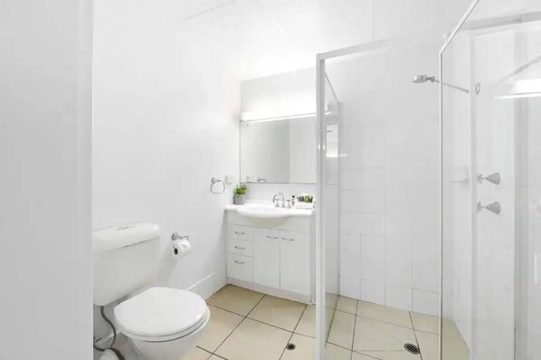 Moderni kylpyhuone, jossa on wc, pesuallas ja suihku.
