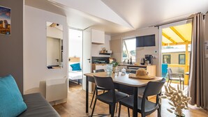 Un espacio de sala y comedor moderno y de planta abierta, con cocina, una mesa de comedor con sillas, un sofá y vistas al exterior.