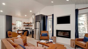 A modern living room with a sofa, armchairs, a coffee table, and a fireplace. - Gorgeous Cabin in the Woods, King Bed, Fire Pit, A/C (Angel Fire)