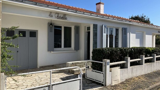 A building with a sign reading 'la Chouille,' a gated entrance, and a stone-paved area.