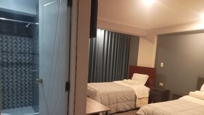 A hotel room with two beds, a shower, and a small table. - MMARROS INN PERU (Cusco)