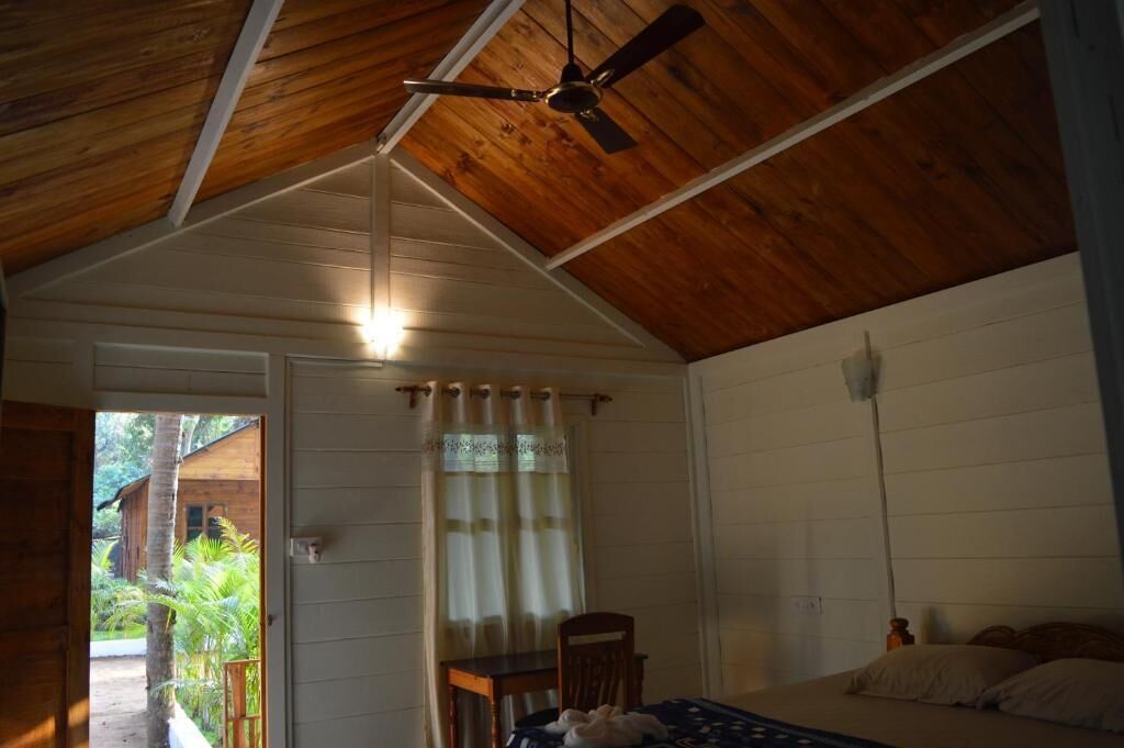 Une pièce avec un plafond en bois, un lit, une table et une chaise.