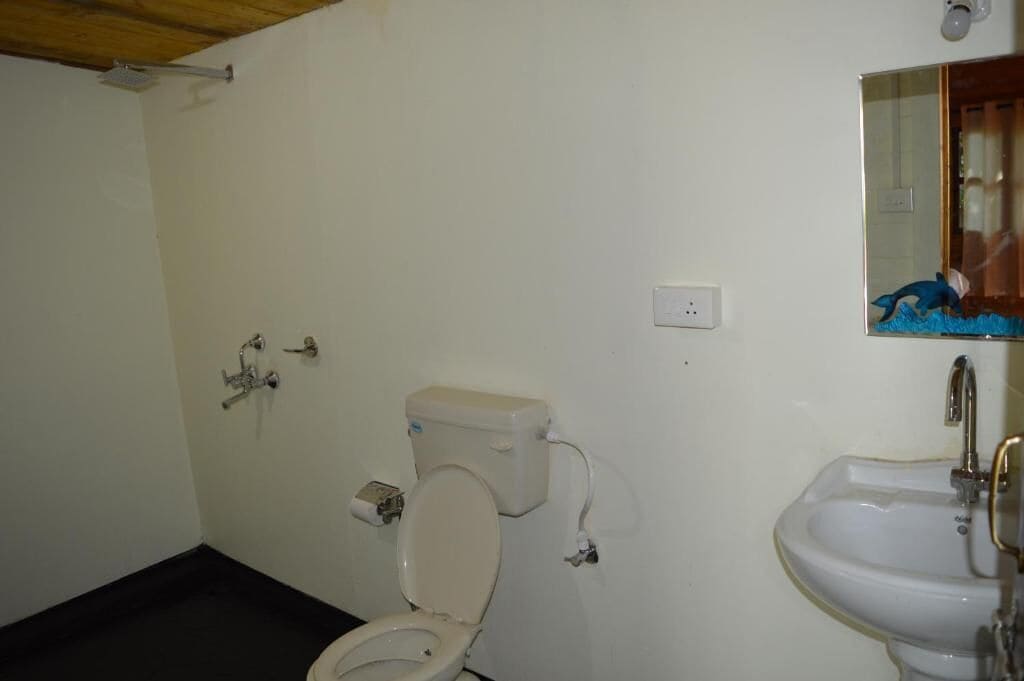 A small bathroom with a toilet, sink, and a mirror.