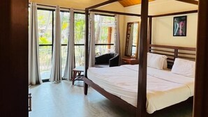 A bedroom with a wooden ceiling, a bed, a ceiling fan, and a window with curtains. - Kings Villa Resort (Canacona)