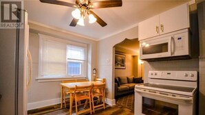 Una cocina compacta con comedor, ventilador de techo y microondas.