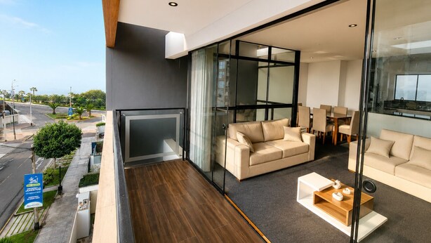 Ein modernes Wohnzimmer mit Balkon, großen Fenstern und Blick auf die Straße.