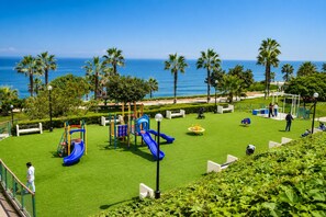 A playground with slides and climbing structures, surrounded by palm trees and a view of the ocean. - Prime Location with Nice Views and Beach Access. Parking available - Fast Wi-Fi. (Miraflores)