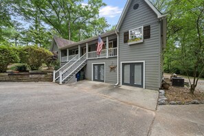 A two-story house with a porch, a staircase, and an American flag.
