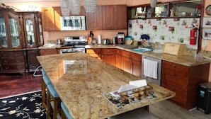 Eine Küche mit einer Granitabdeckung, Holzschränken und einem eingebauten Backofen.