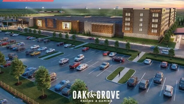 Un estacionamiento amplio con varias filas de coches y un edificio con el rótulo "Oak Grove Casino" al fondo.