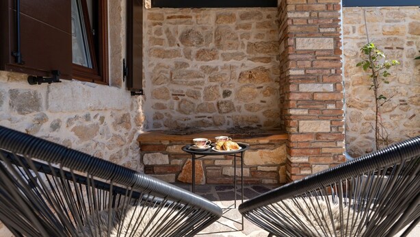 A stone wall with a built-in grill and a small table with a cup and pastries. - Villa Stonehouse (Istria - Umag) (Umag)