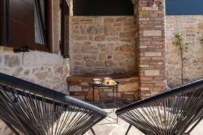 A stone wall with a built-in grill and a small table with a cup and pastries. - Villa Stonehouse (Istria - Umag) (Umag)