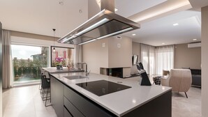 A modern kitchen with a large island, built-in appliances, and a view to the outdoors. - Villa Panamera (Istria - Poreč) (Poreč)
