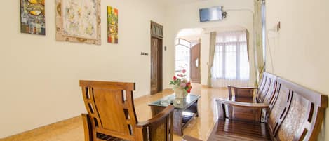 Un vestíbulo de hotel con muebles de madera, un televisor de pantalla plana y obras de arte en las paredes.
