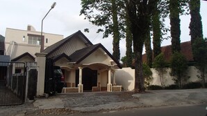 A residential building with a pitched roof, a covered porch, and a gated entrance. - Shakila Guest House (Batu)