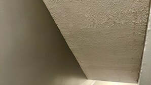 Una escalera con barandilla blanca que lleva a un rellano.