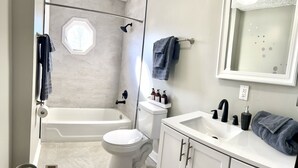 Un baño con bañera, inodoro y lavabo.
