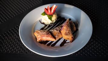 A plate with a dessert consisting of a triangular pastry, a scoop of ice cream, and a strawberry garnish.