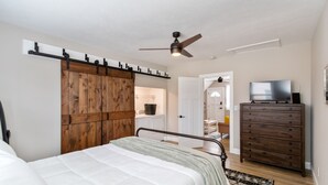 A bedroom with a bed, a dresser, a television, and a ceiling fan. - Welcome to the Boar's Nest, walking distance to Noblesville town square  (Noblesville)