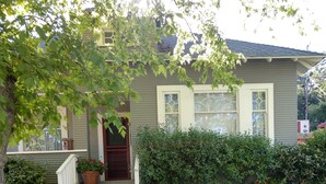 A two-story house with a front porch, a small garden, and a well-maintained lawn. - Cozy Home on Vine Street  (Paso Robles)