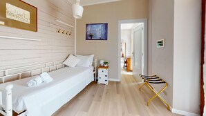 Un dormitorio moderno con cama, mesita de noche y vistas a un comedor.