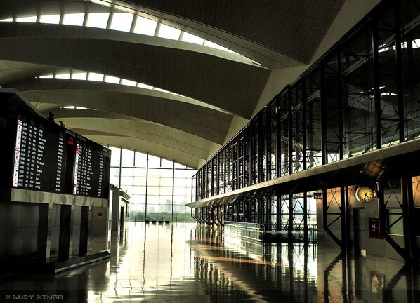 A spacious indoor area with a high ceiling and large windows allowing natural light.