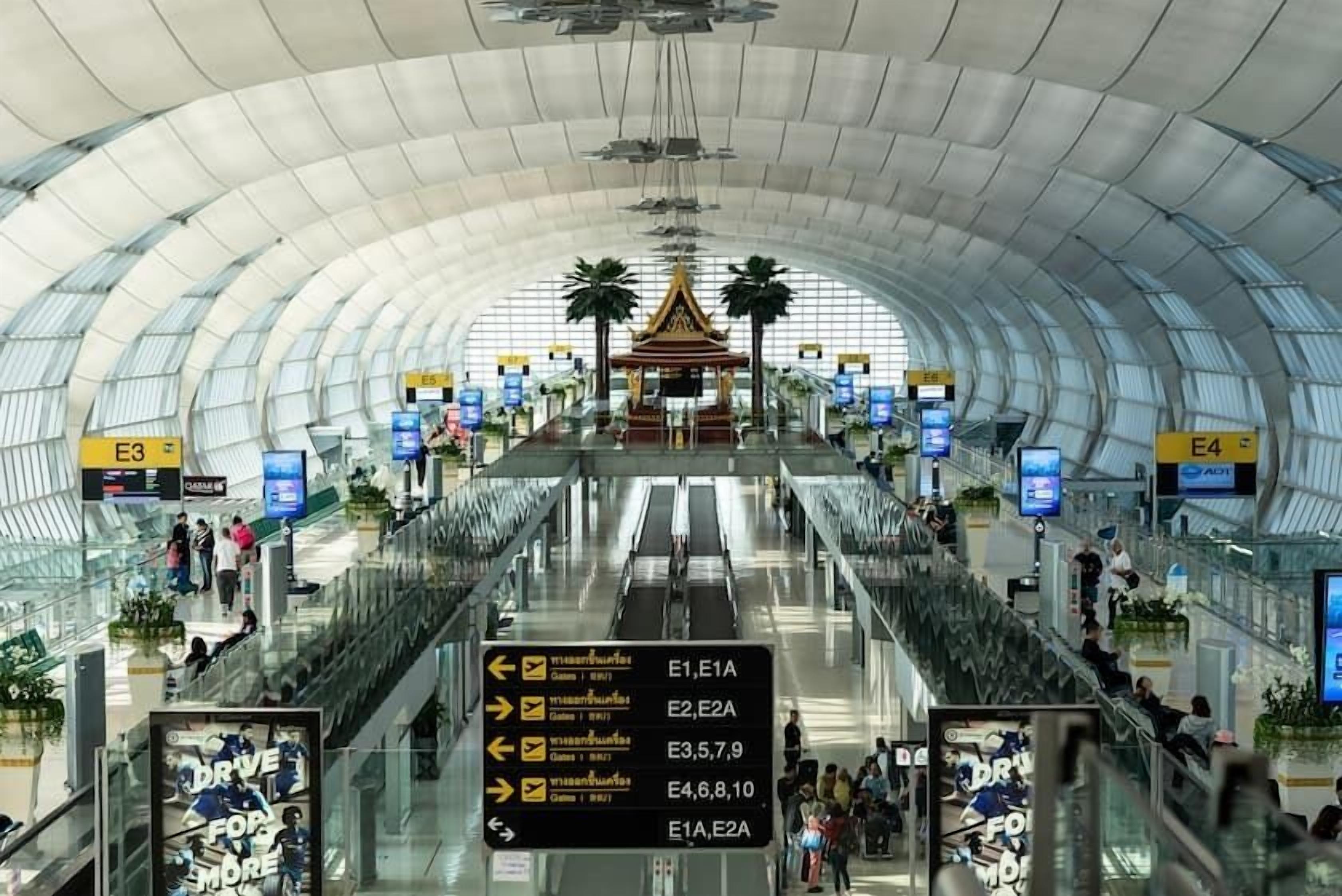 An airport terminal with clear signage for gates E1, E2, E3, E4, E5, E6, E7, E8, E9, E10, E11, E12, E13, E14, E15, E16, E17, E18, E19, E20, E21, E22, E23, E24, E25, E26, E27, E28, E29, E30, E31, E32, E33, E34, E35, E36, E37, E38, E39, E40, E41, E42, E43, E44, E45, E46, E47, E48, E49, E50, E51, E52, E53, E54, E55, E56, E57, E58, E59, E60, E61, E62, E63,