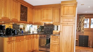 A spacious kitchen with wooden cabinets, a stainless steel oven, and a granite countertop.