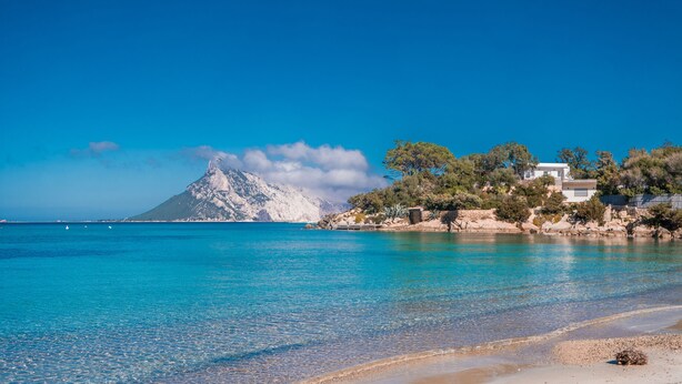 A coastal landscape with a clear blue sea, a sandy beach, and a mountain in the background. - Quiet Sanibel, Monte Petrosu, Italy (Monte Petrosu)