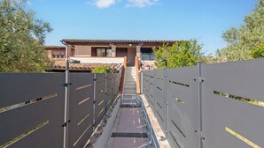 Un sendero que lleva a un edificio con tejado de baldosas y un balcón.