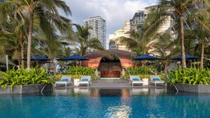 A swimming pool with lounge chairs and umbrellas, surrounded by palm trees and modern buildings. - ITC Ratnadipa, a Luxury Collection Hotel, Colombo (Colombo)