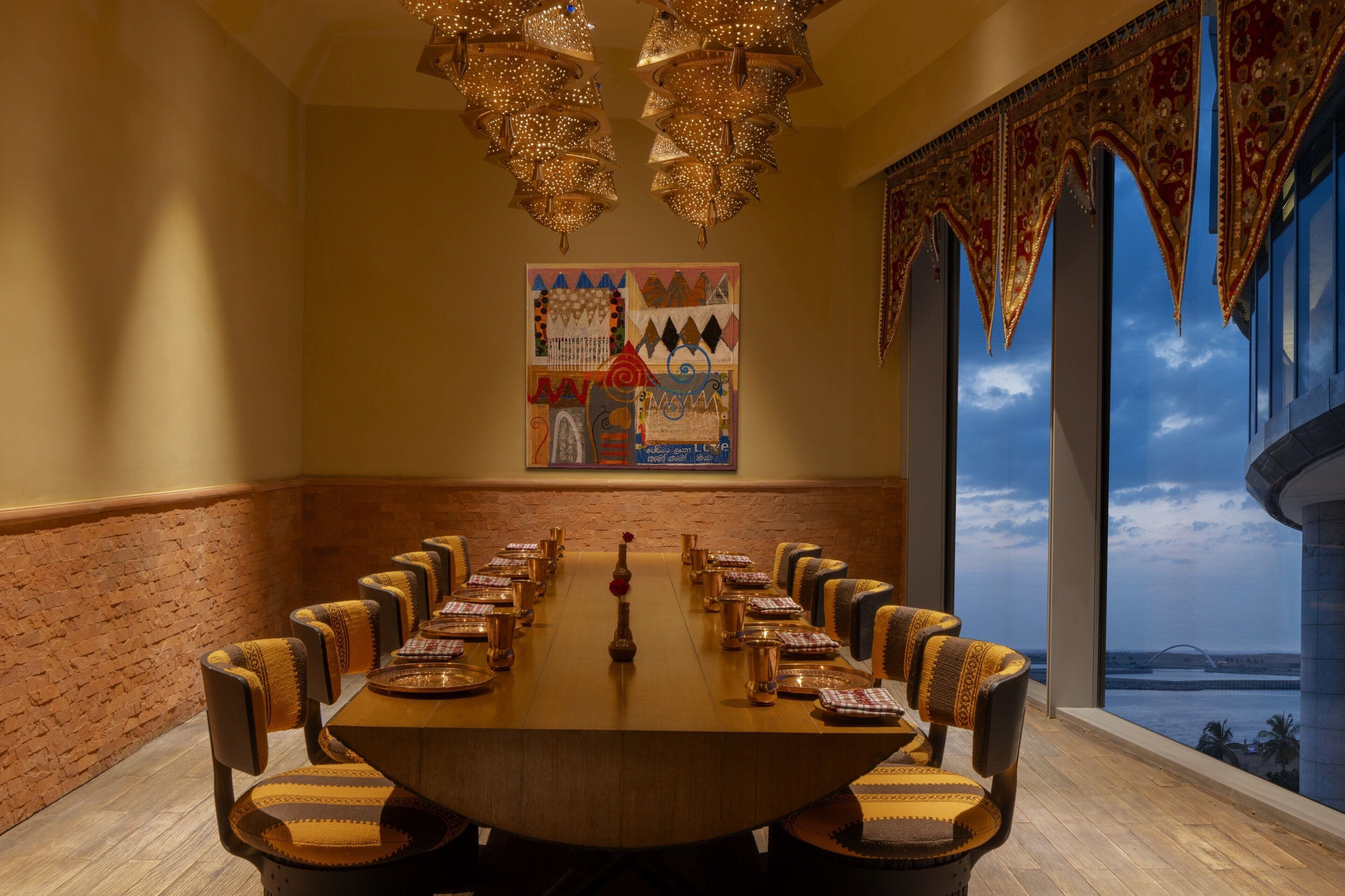 A conference room with a long table, chairs, and a large window with a view of a bridge and water.
