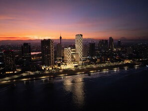 A cityscape at dusk with prominent skyscrapers, a waterfront, and a river. - ITC Ratnadipa, a Luxury Collection Hotel, Colombo (Colombo)