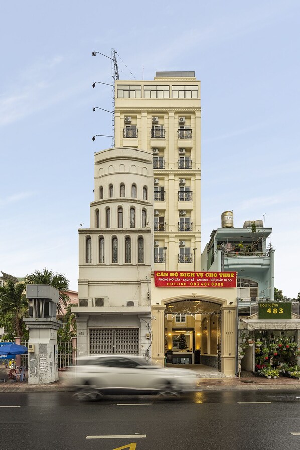 A multi-story hotel with a prominent entrance, a signboard, and a water tank on the roof.