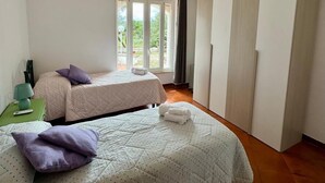 A room with two beds, a green nightstand, and a large window. - Capivento   typical Apulian trullo in the countryside (CEGLIE MESSAPICA)