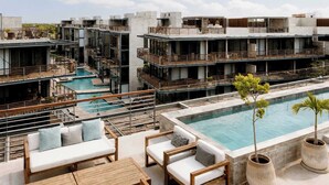 A rooftop pool area with multiple levels of outdoor seating and a central swimming pool. - Paradise Penthouse | Cenote, Rooftop Pool & Sauna (Tulum)