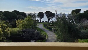 A pathway leading to a body of water with trees and a gazebo.