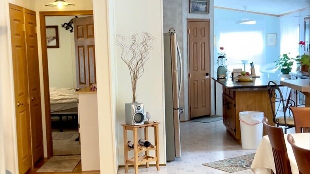 A spacious kitchen with wooden flooring, a dining area with a table and chairs, and a hallway leading to a bedroom. - SkyGazers Delight. One of the Safest areas in Bloomington. Super easy access!! (Bloomington)