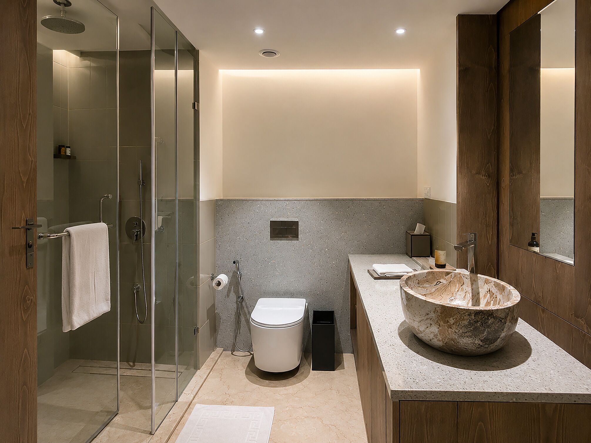 Un baño moderno con cabina de ducha de vidrio, lavamanos de mármol y un lavabo espacioso.