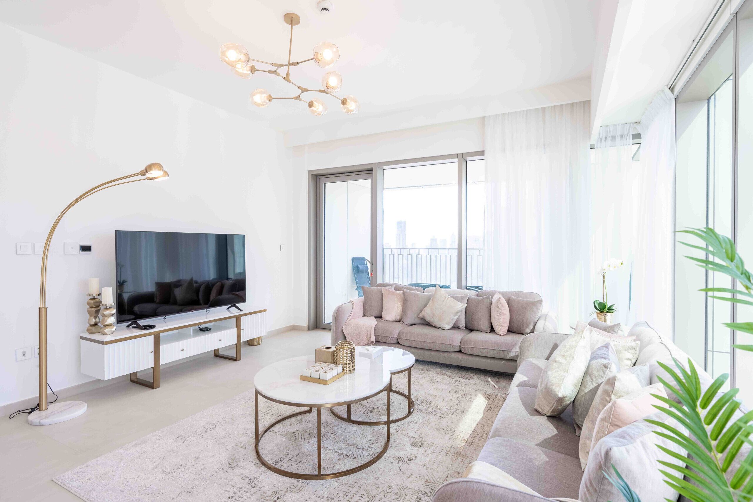 A modern living room with a sofa, a coffee table, a TV, and a floor lamp.