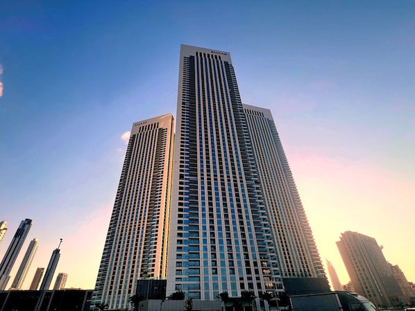 Un immeuble de grande hauteur doté d’une architecture moderne, caractérisé par un motif vertical bien marqué et un toit plat.