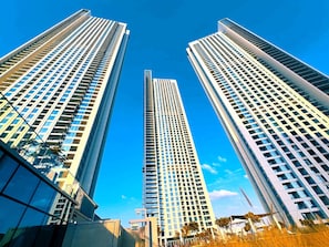 Trois immeubles de grande hauteur se dressent sous un ciel d’un bleu éclatant.