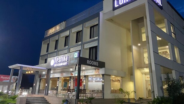 Un hotel moderno con un cartel que dice 'Luxury Hotel', un restaurante llamado 'Festiva Restaurant' y una sección de 'Rooms'.