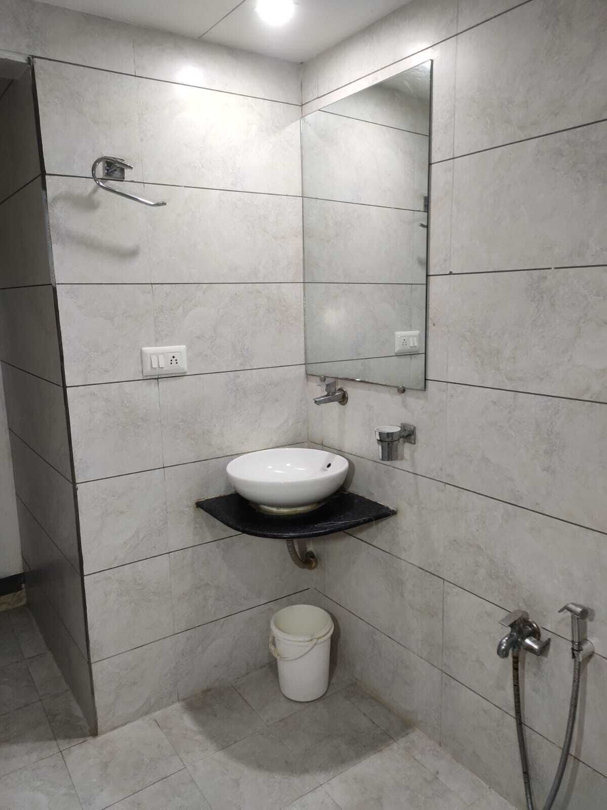 A bathroom with a white sink, a mirror, and a shower.
