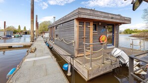 Una estructura flotante con un muelle, una bomba de agua y un pequeño edificio con un letrero.