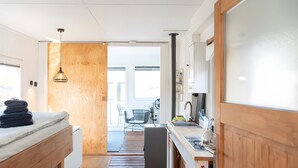 Une cuisine de taille réduite, dotée d’un plan de travail en bois, d’un évier et d’un réfrigérateur.