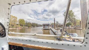 A view from a boat's window, including a lock system, a small building, and trees along the water.