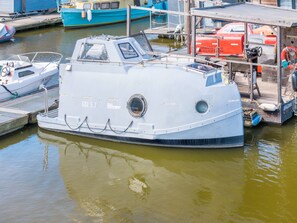 Ein festgemachtes Boot in einer Marina, mit deutlich sichtbarer Rumpfnummer und Rettungsboje.